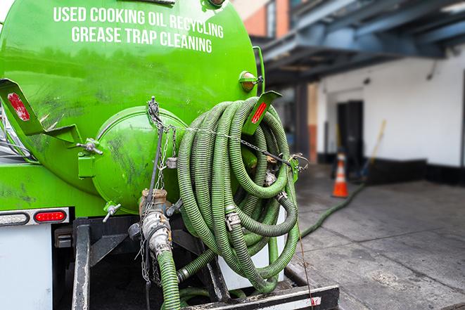 a technician pumping a grease trap in a commercial building in Ecorse